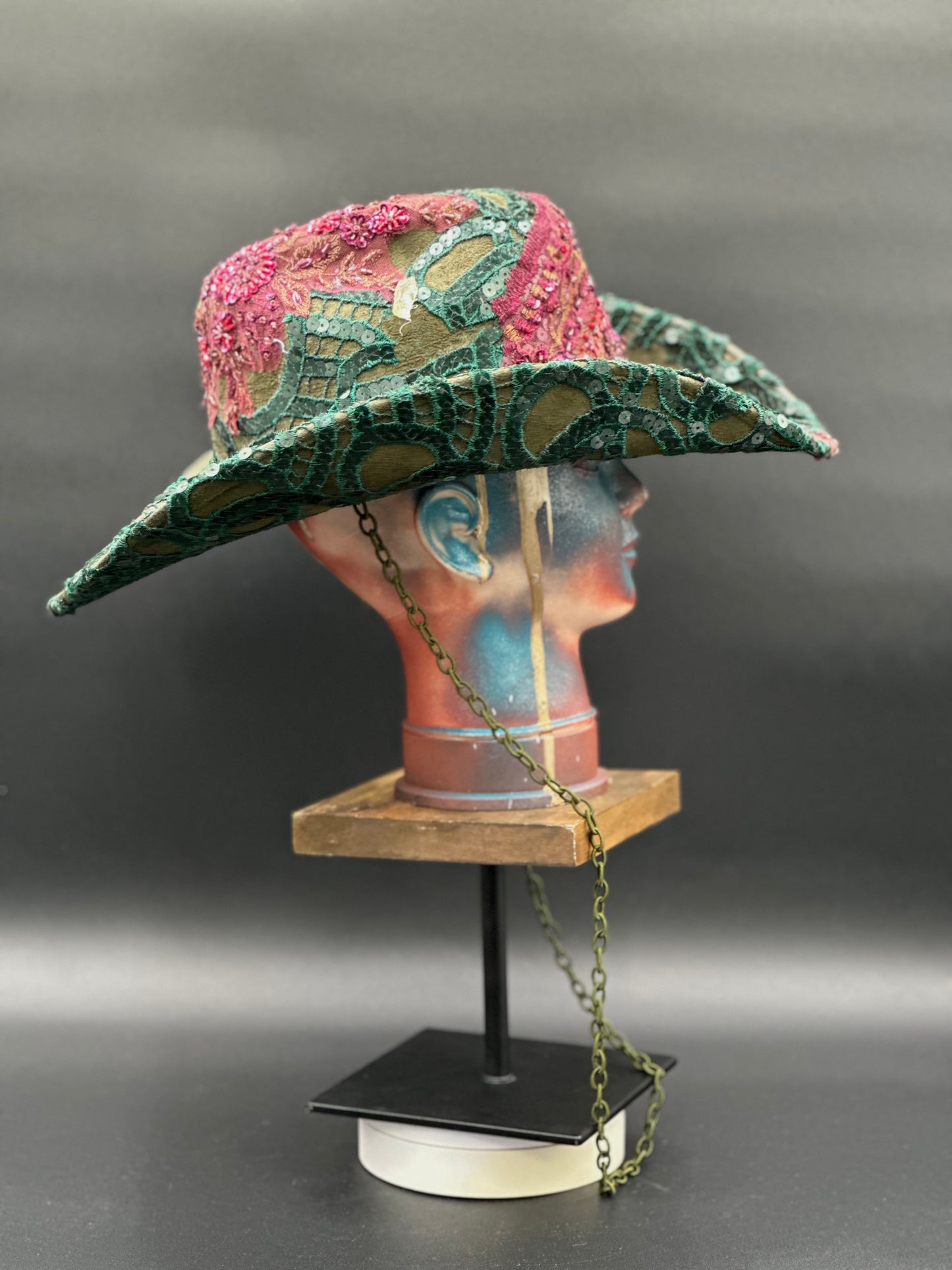 Side view of the Deep Forest Green Suede Cowboy Hat on a mannequin head, highlighting the stoned lace placement and the hat's silhouette.