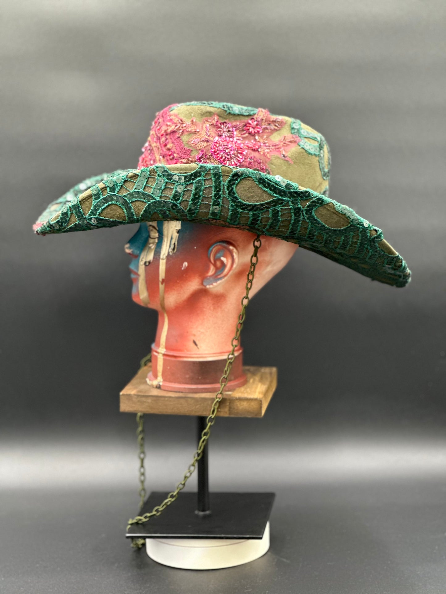 Angled view of the Deep Forest Green Suede Cowboy Hat on a mannequin head, displaying the texture of the suede, embroidery, and embellishments.