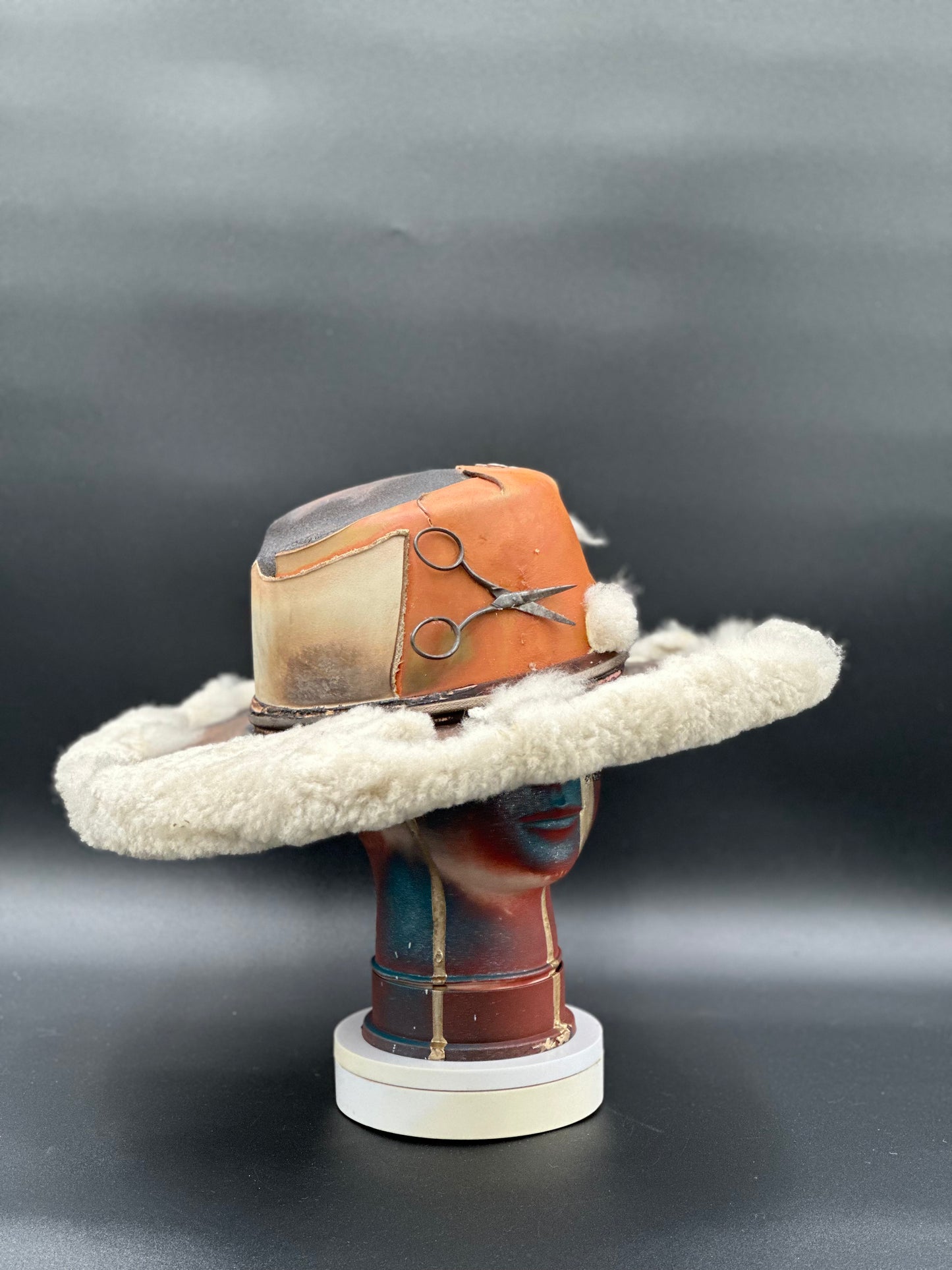 Angled view of the Dinamarca Caramel Cordobés Hat, displaying the texture of the fabric and the placement of the scissor detail and fur.