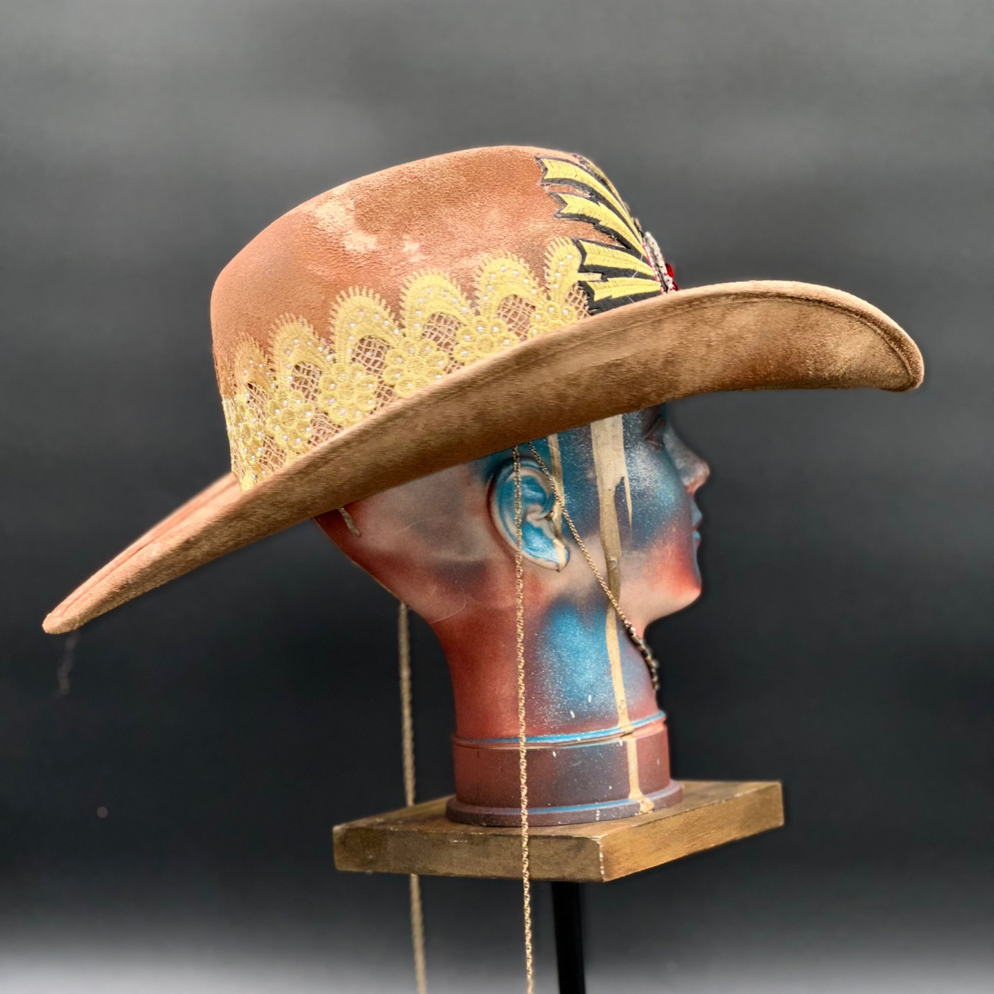 Side view of the Portugal Caramel Suede Cowboy Hat on a mannequin head, highlighting the crystal composition and the hat's silhouette.
