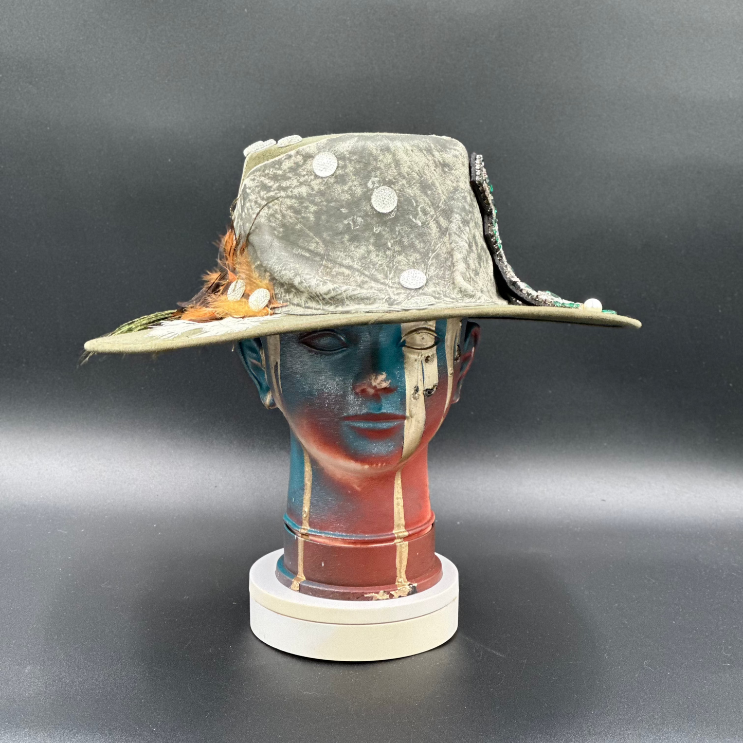 Valencia Green Cordobés Hat with a crystal cross centerpiece, green leather trim, and feathers. Front view showing the hat's full design and shape.