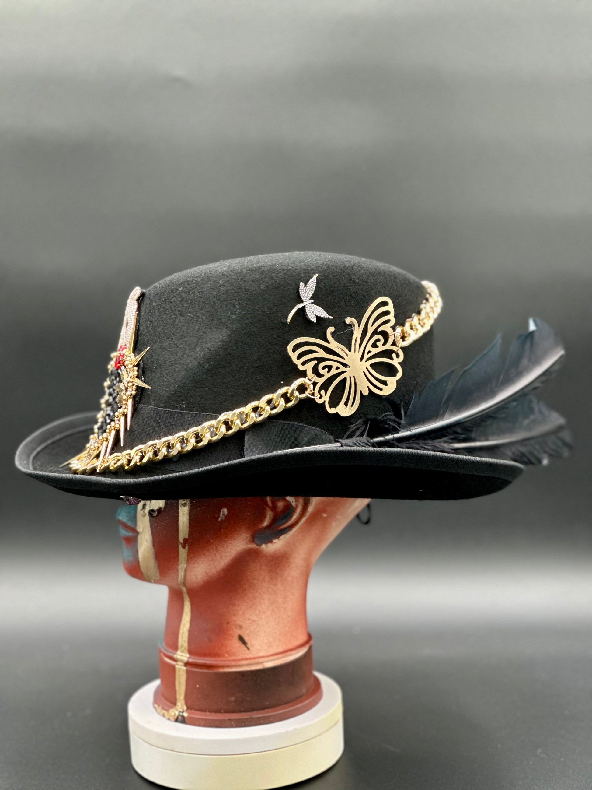 Angled view of the Berlin Black Wool Top Hat, displaying the texture of the wool and the arrangement of the chains and spikes.