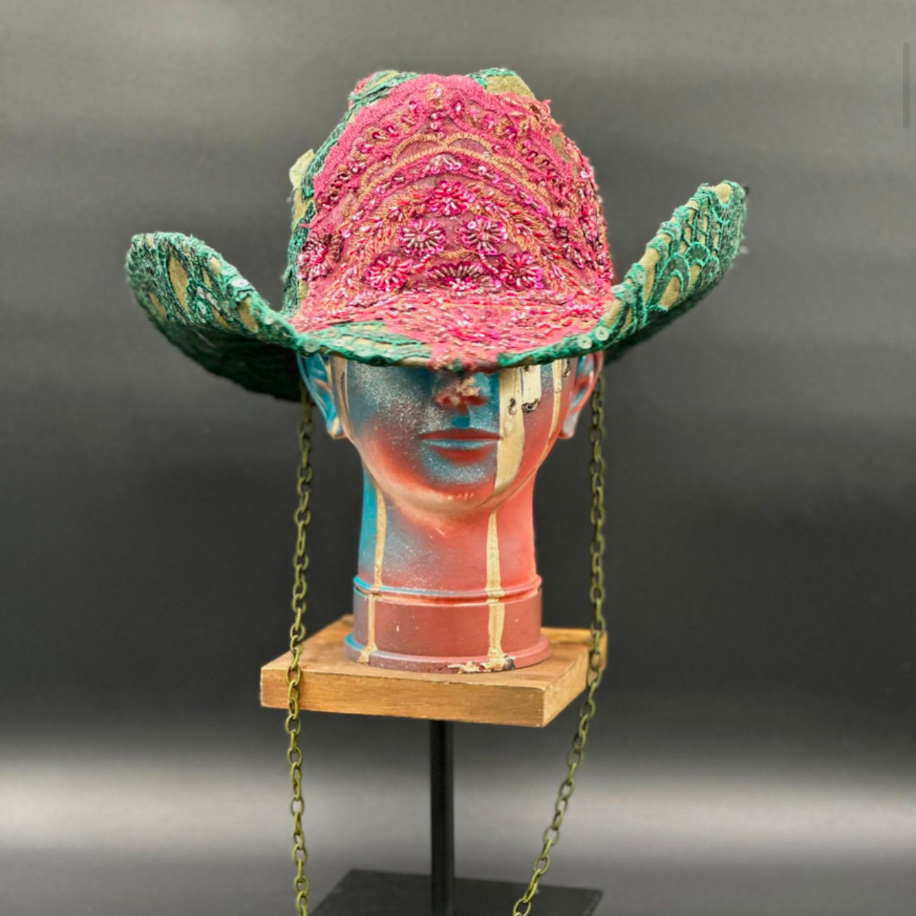 Deep Forest Green Suede Cowboy Hat with emerald green embroidery, a stoned burgundy lace centerpiece, and shimmering embellishments displayed on a mannequin head. Front view showing the hat's full design and shape.