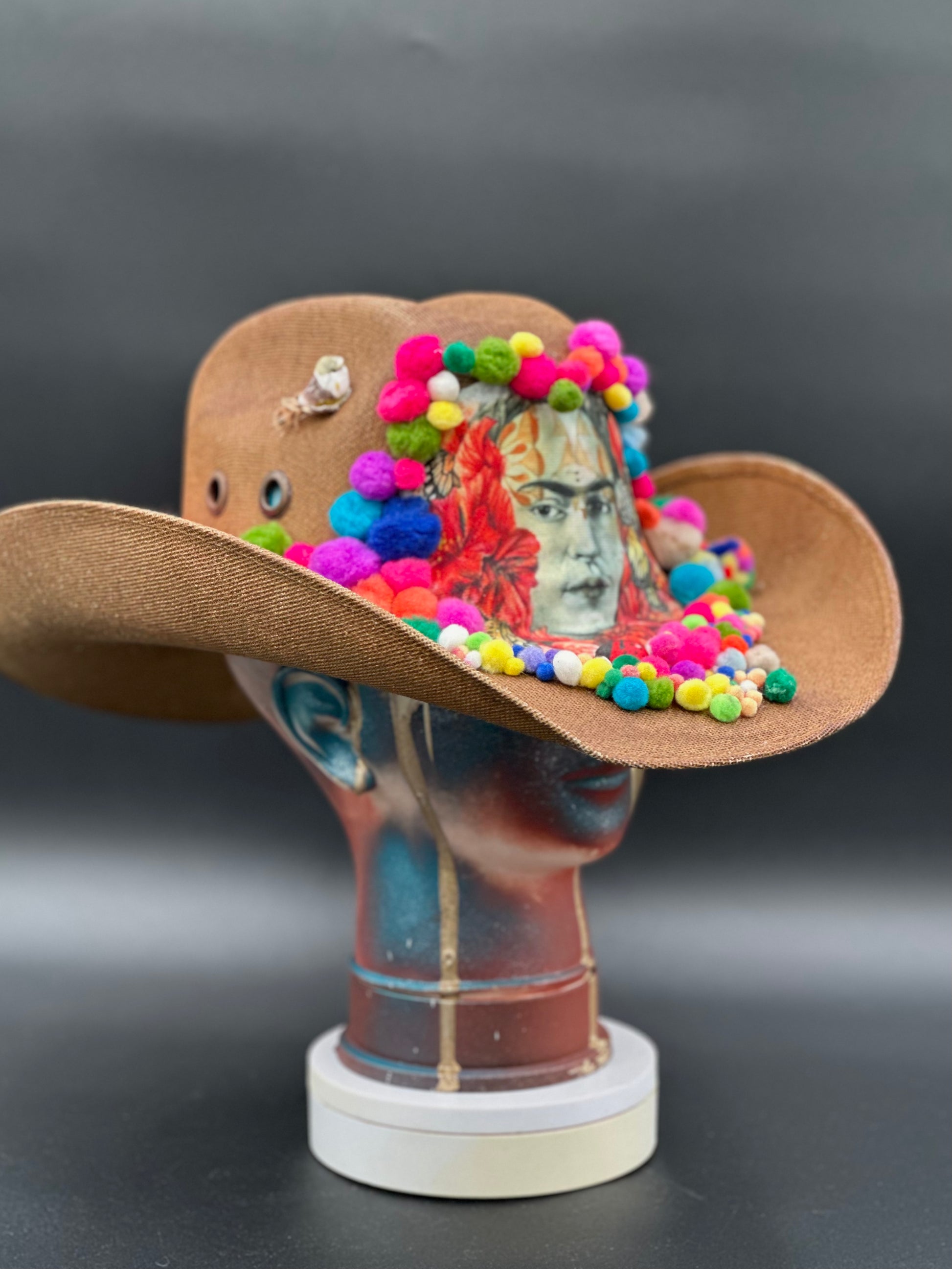 Angled view of the Frida in Cotton Cowboy Hat on a mannequin head, displaying the texture of the straw and the colorful embellishments.