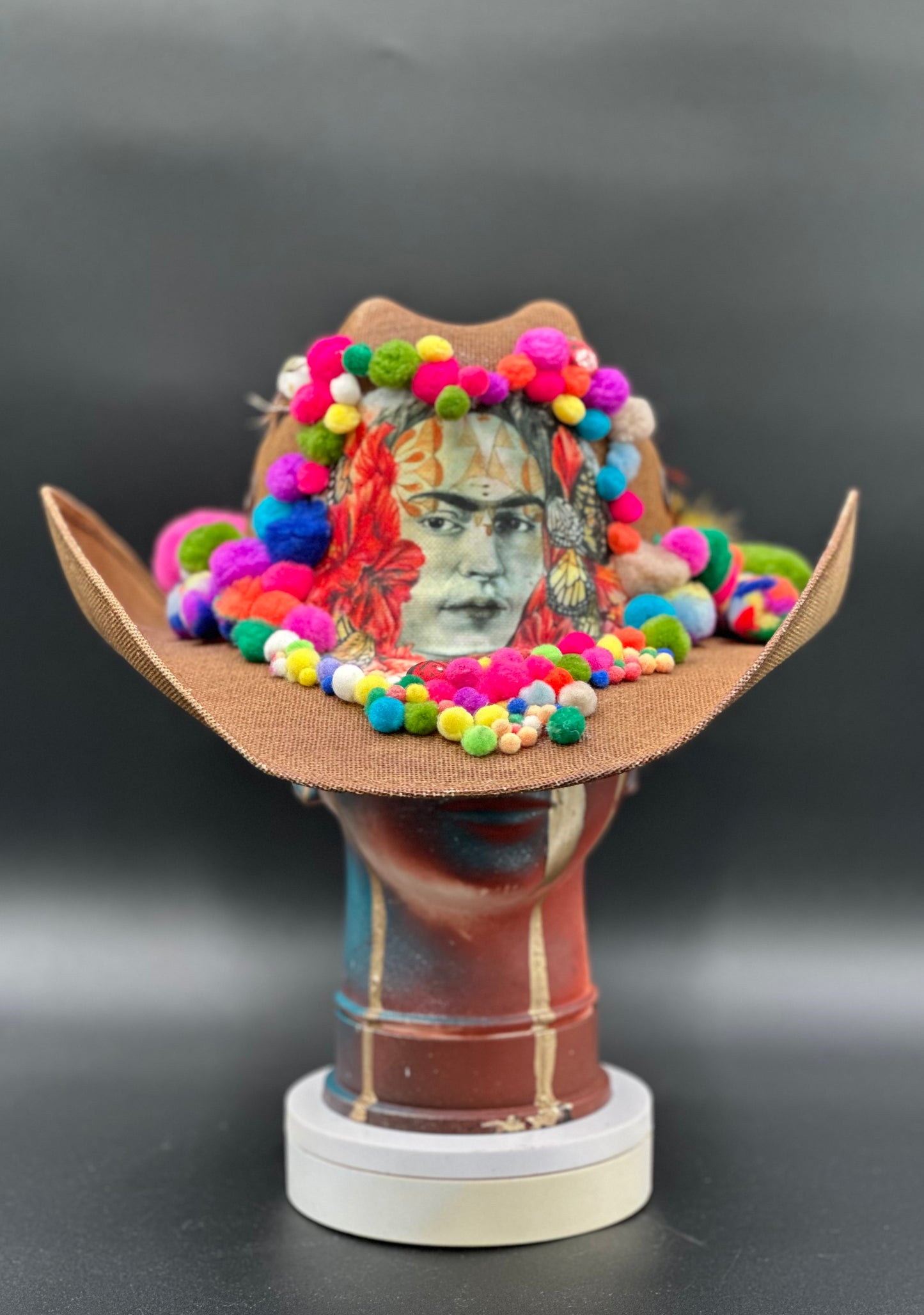 Frida in Cotton - Brown Straw Cowboy Hat with a colorful design displayed on a mannequin head. Front view showing the hat's full design and shape.