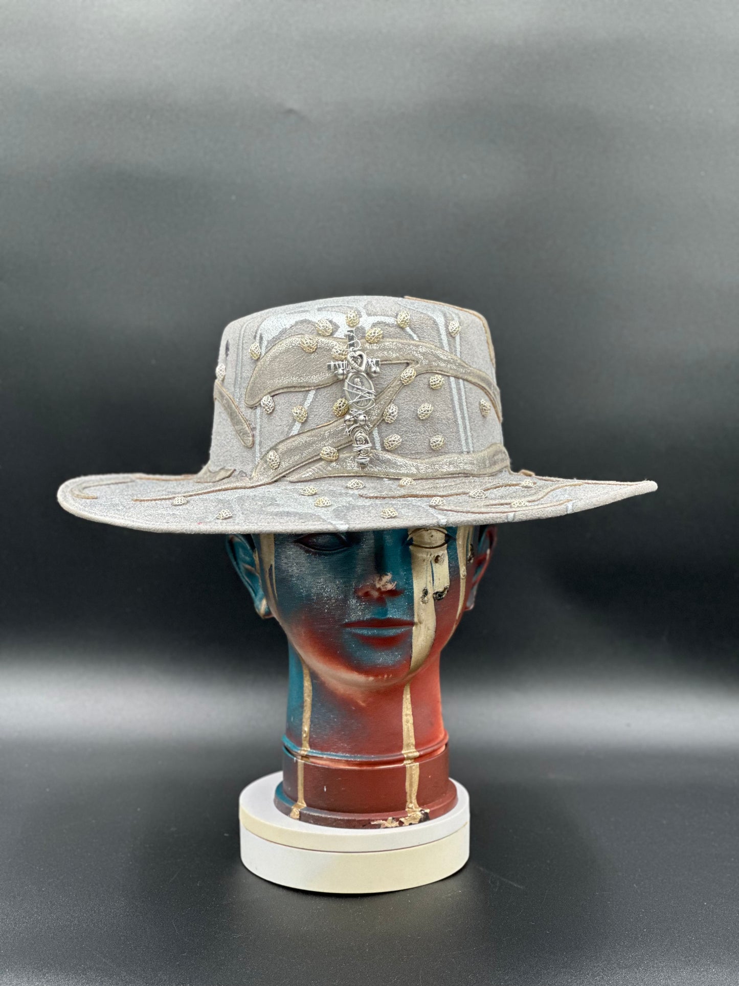 Ibiza Hand-Painted Silver Glitter Cordobés Hat with metallic pieces and a handmade cross detail displayed on a mannequin head. Front view showing the hat's full design and shape.