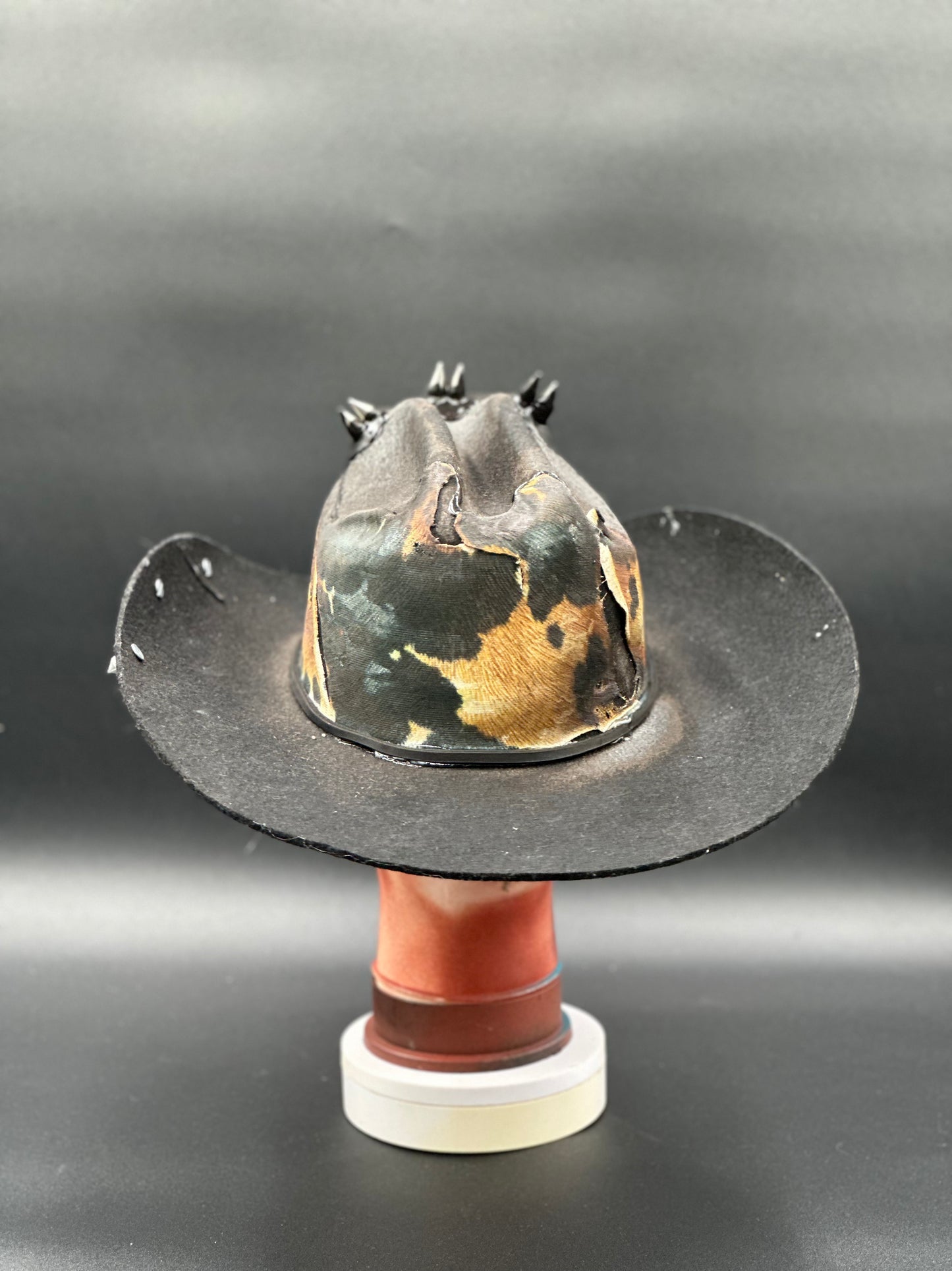 Angled view of the London Black Wool Cowboy Hat, displaying the cowhide prints, spikes, and overall texture.