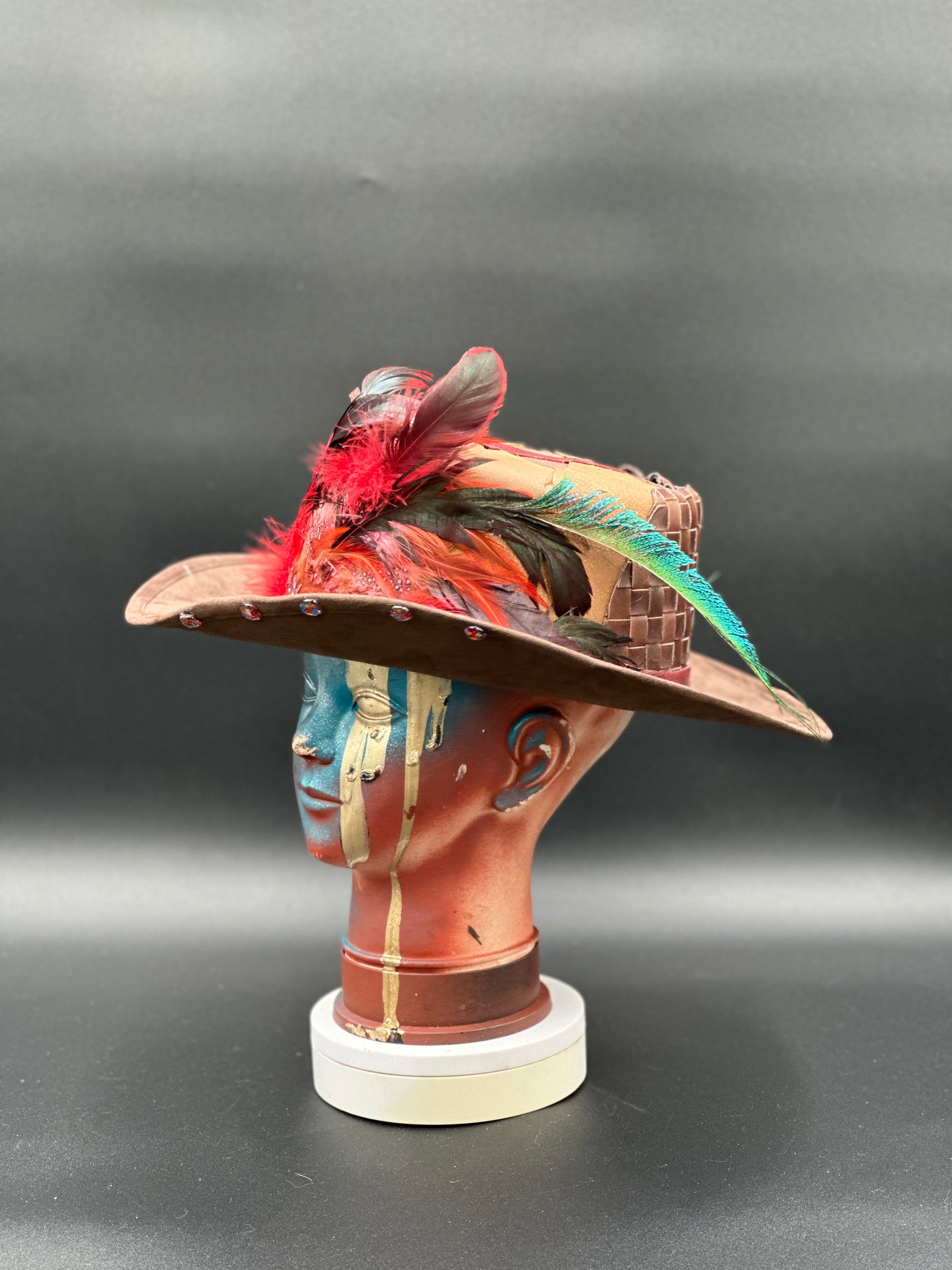 Angled view of the Madagascar Crimped Tobacco Cordobés Hat, displaying the crimped texture and the placement of the feathers and charms.