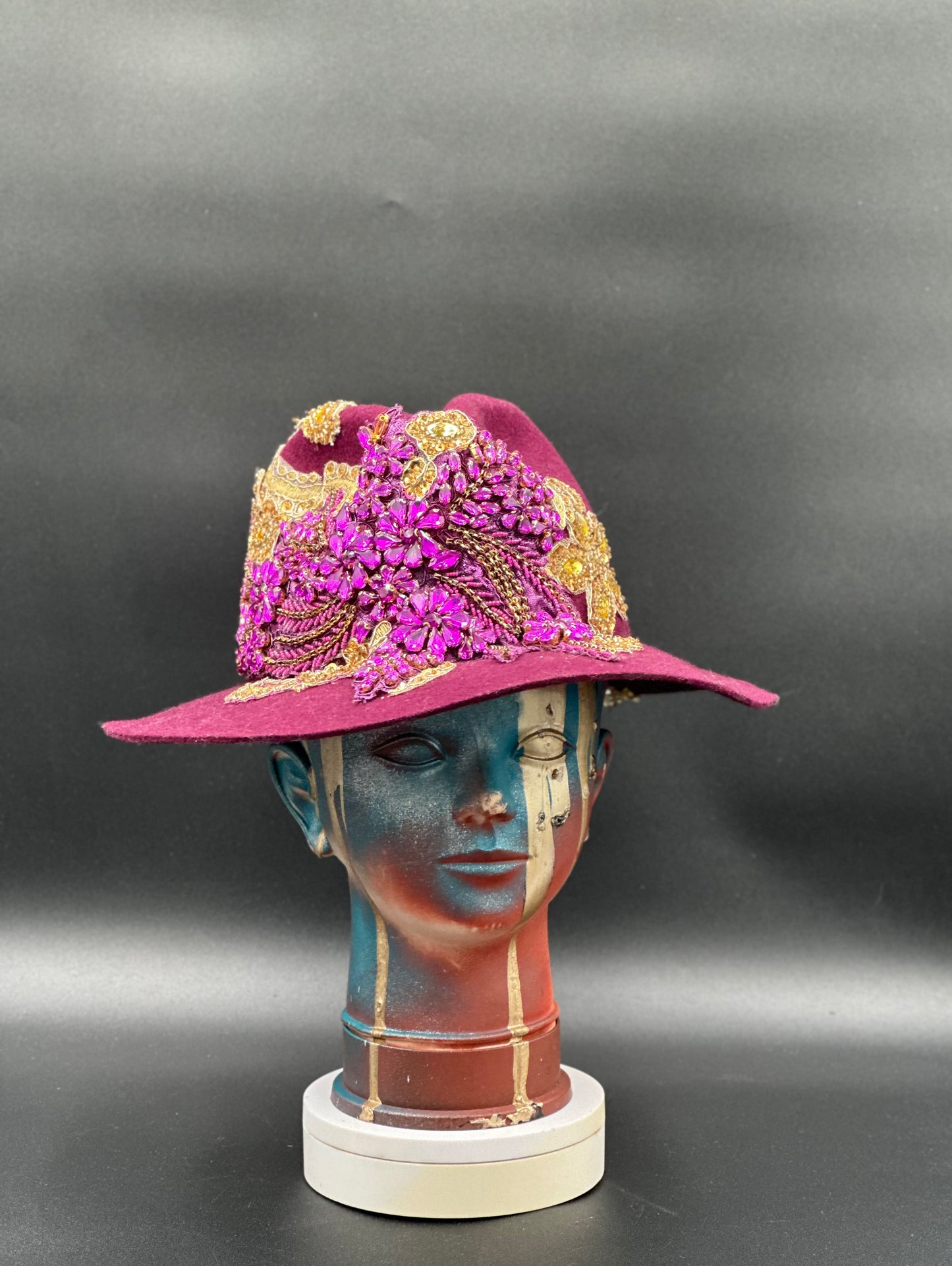 O'porto Magenta Wool Fedora Hat on a mannequin head, showcasing the hat's elegant style and vibrant color.