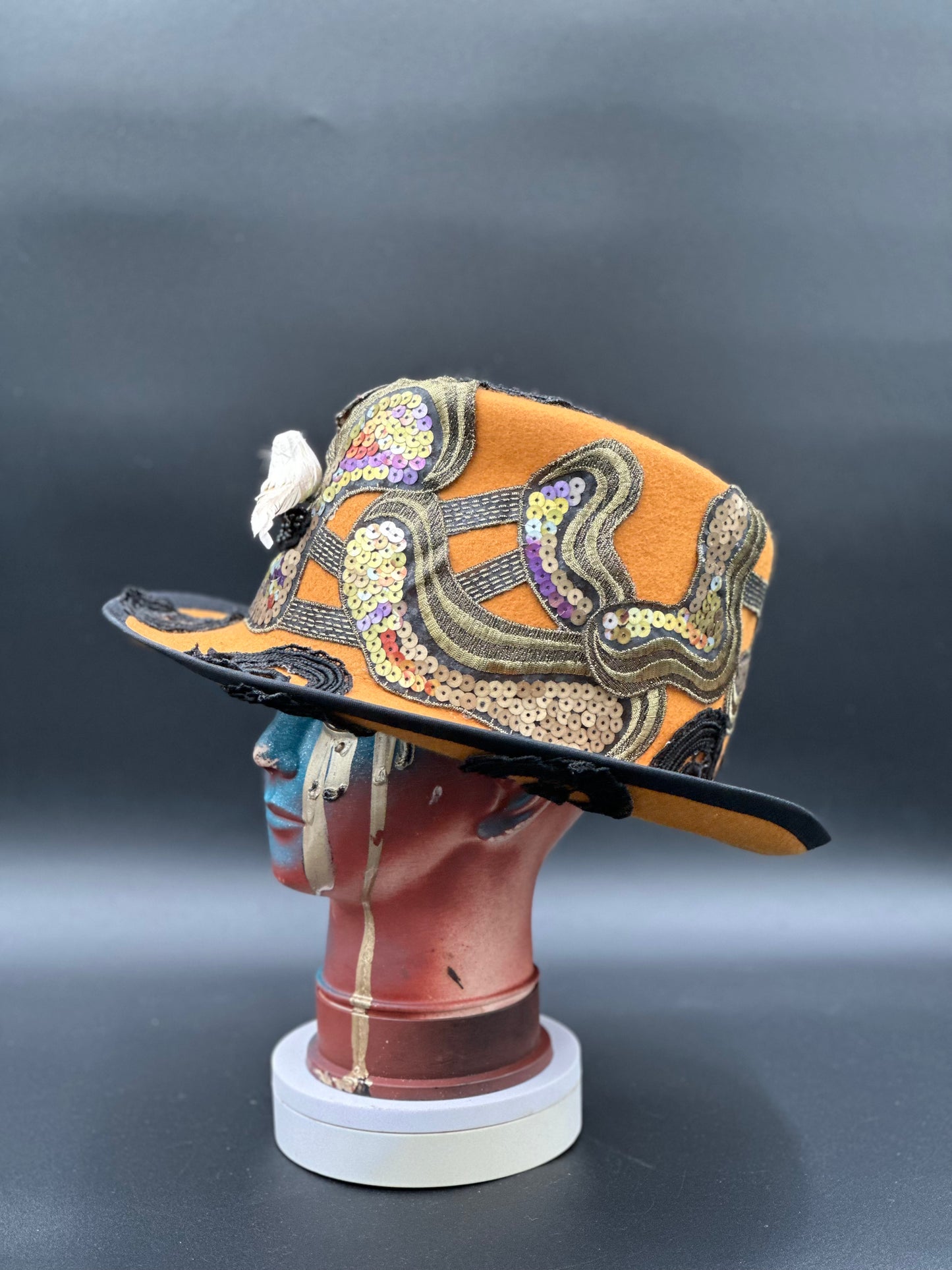 Angled view of the New Orleans Mustard Wool Top Hat, showcasing the fabric texture, sequins, and overall design.