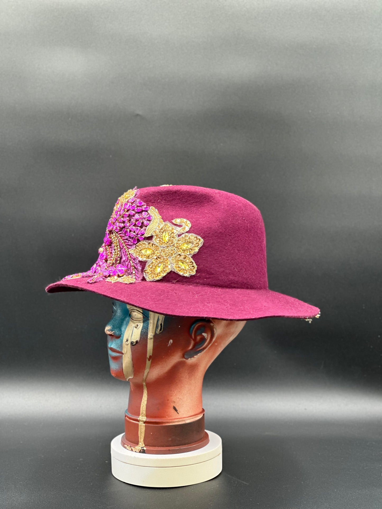 Side view of the O'porto Magenta Wool Fedora Hat on a mannequin head, highlighting the crystal placement and the hat's silhouette.