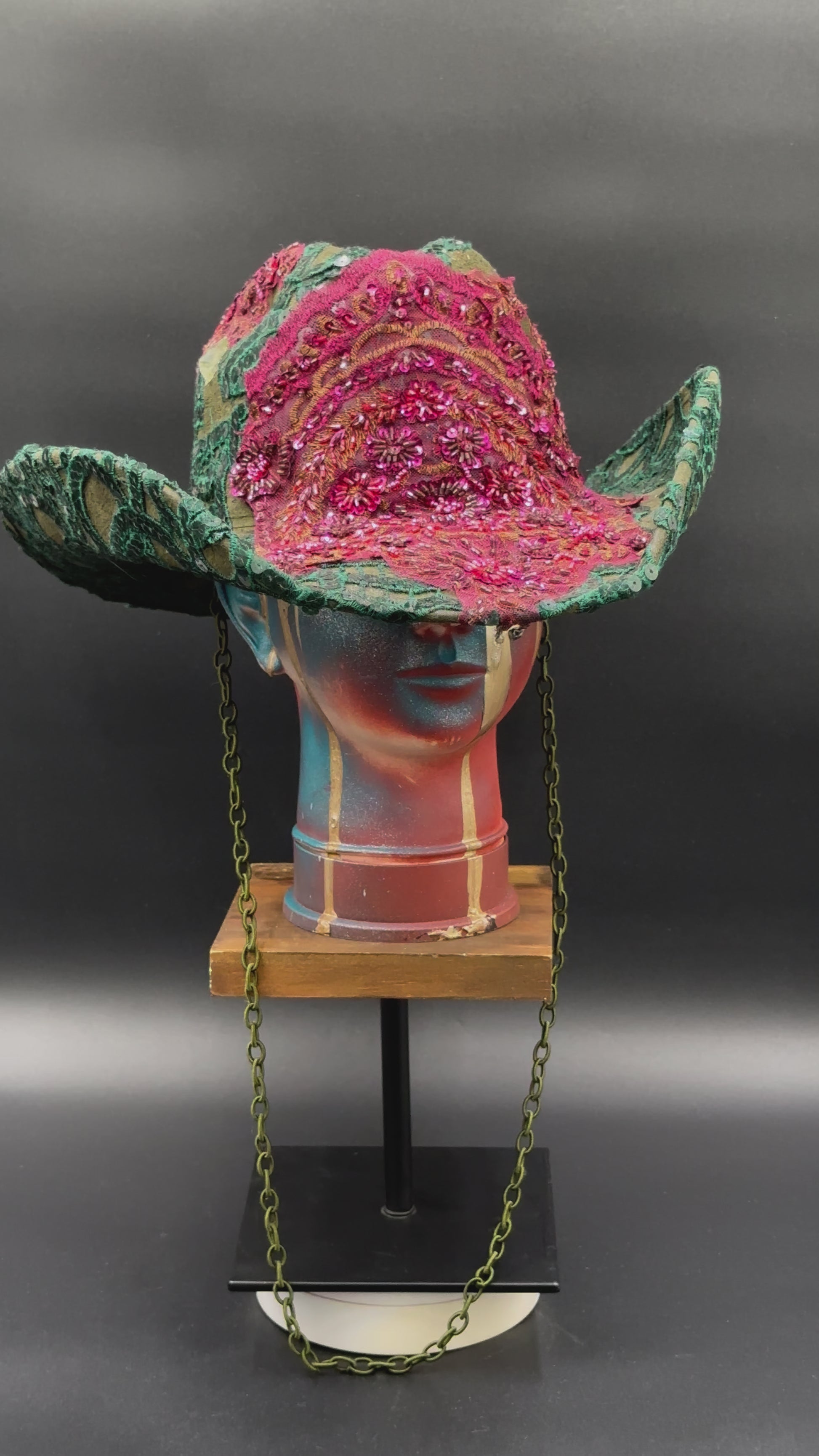 360-degree video of the Deep Forest Green Suede Cowboy Hat rotating on a mannequin head, showcasing the hat's full design, green suede texture, emerald embroidery, stoned lace centerpiece, and shimmering embellishments from all angles.